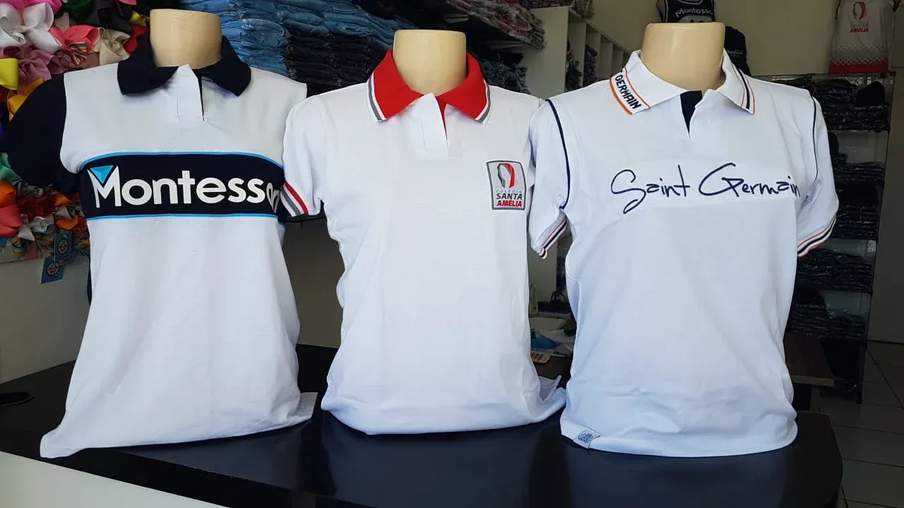 Uniformes escolares de três instituições de ensino em manequins na loja Acqua Fardamentos